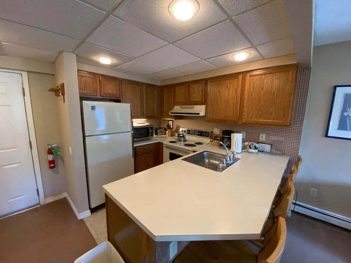 A view of the kitchen area with a central island, modern appliances, and wooden cabinetry. The layout encourages communal cooking, meal prep, and casual conversation, with ample space for family gatherings or preparing holiday feasts.